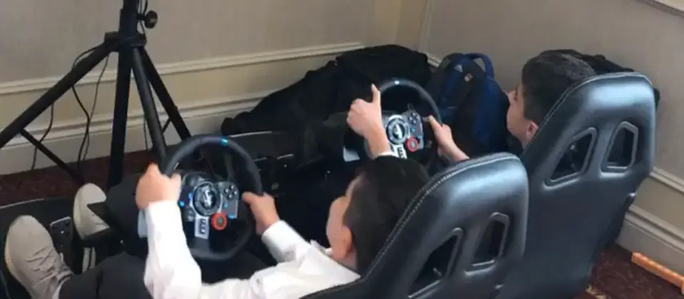 Kids in racing simulator seats with steering wheels