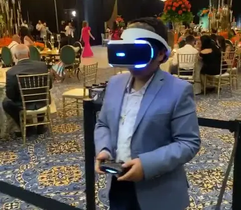 Boy in a suit playing with a VR headset at a banquet
